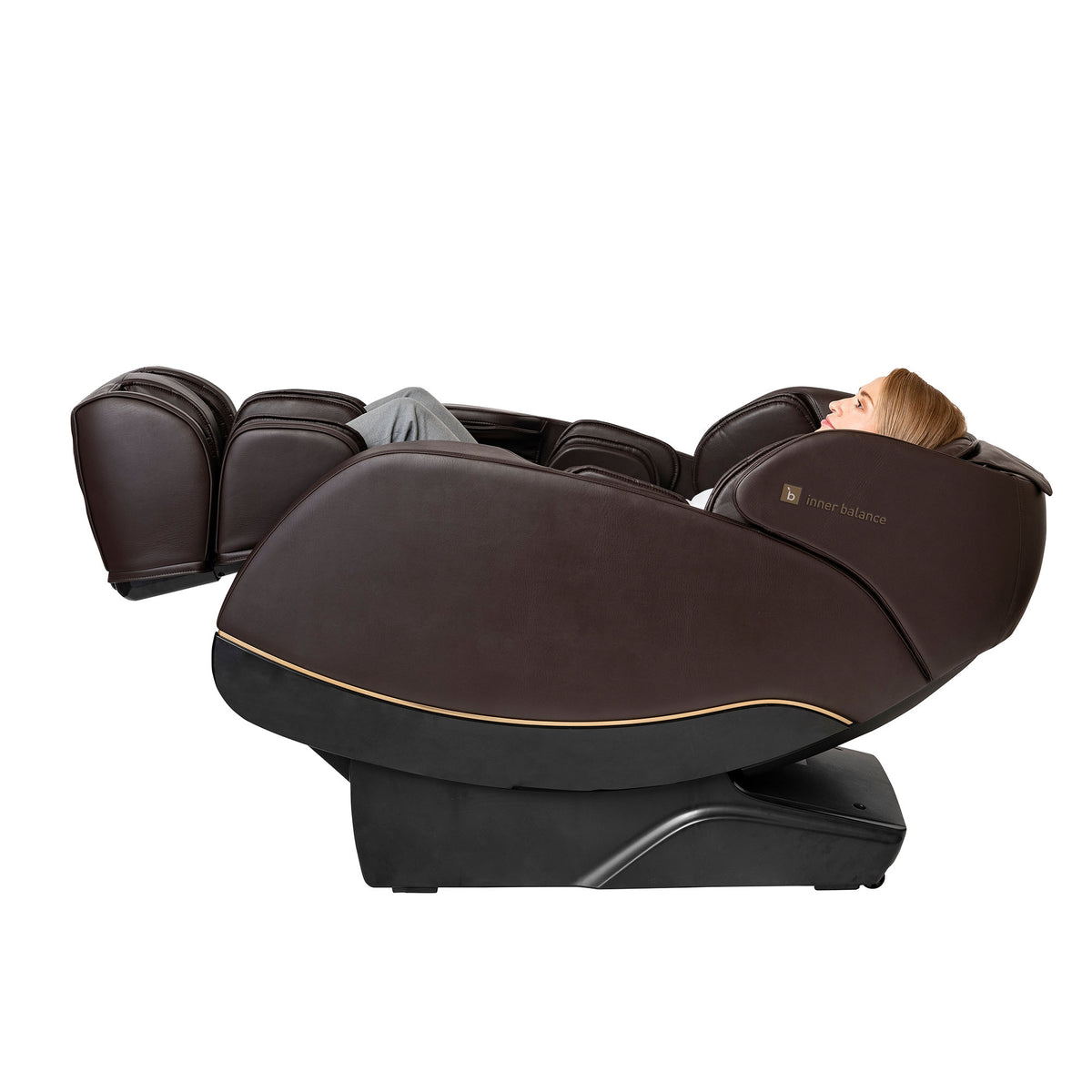 Woman enjoying a fully zero-gravity reclined Inner Balance Jin 2.0 Massage Chair upholstered in brown leather with gold trimmings